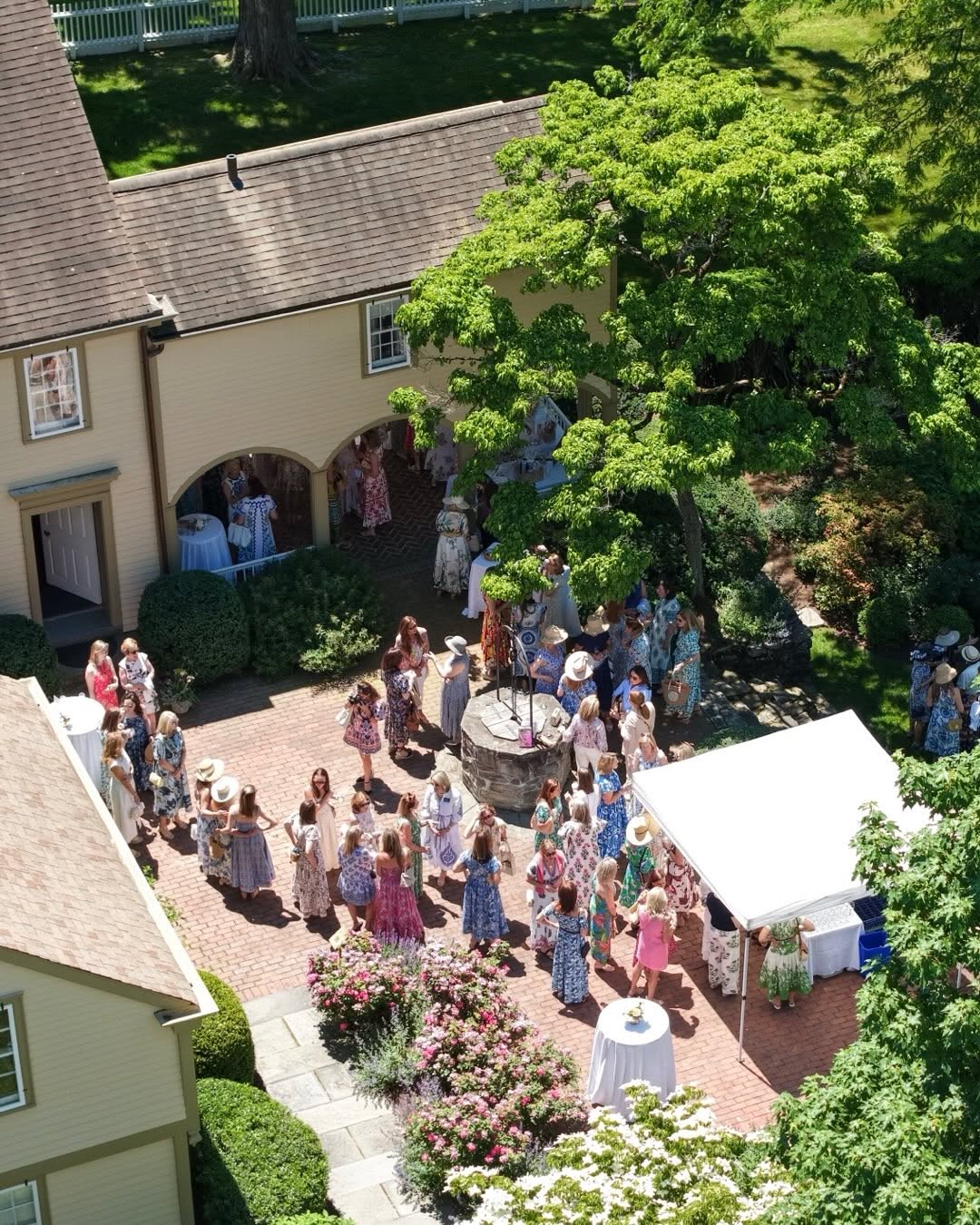 An aerial view of the Museum of Darien in Darien, Connecticut, showing the historic property, landscaped courtyard, mature trees, and visitors gathered for an outdoor community event.