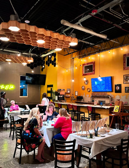 Interior of Alvarium Beer Company in New Britain, Connecticut, featuring guests gathered around tables, a modern taproom with exposed industrial elements, local craft beer taps, and a welcoming community atmosphere.