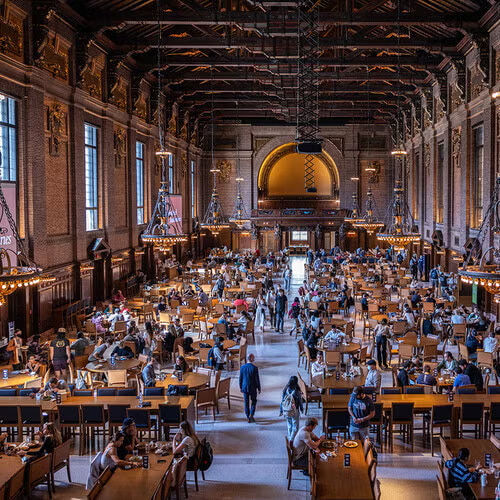 Interior of Yale University’s Beinecke Library study space in New Haven, Connecticut, showing a grand hall filled with long wooden tables, students studying, and ornate architectural details.