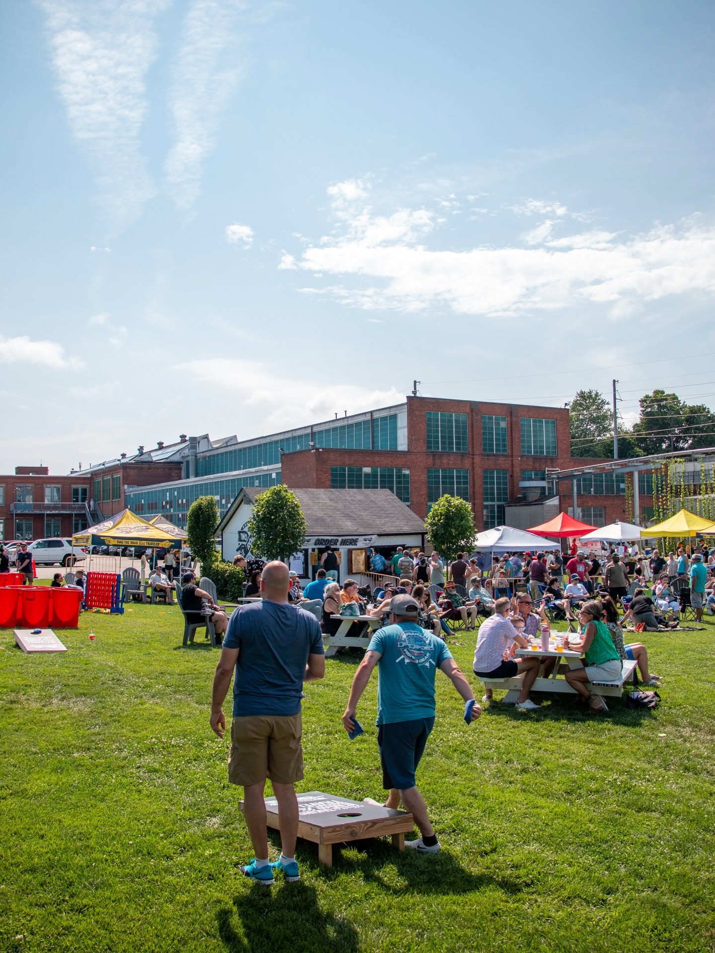 Visitors gather on the lawn outside Two Roads Brewing Company in Stratford, Connecticut, enjoying food vendors, lawn games, and outdoor seating during a community event.
