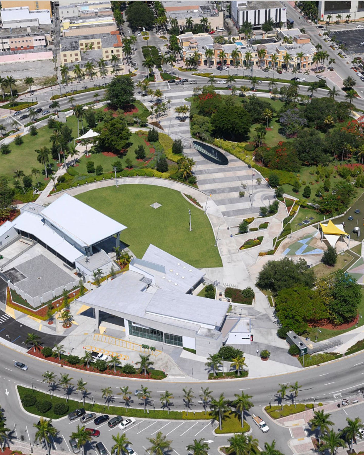 Aerial view of the ArtsPark at Young Circle amphitheater and green space in downtown Hollywood, Florida surrounded by palm trees and urban development