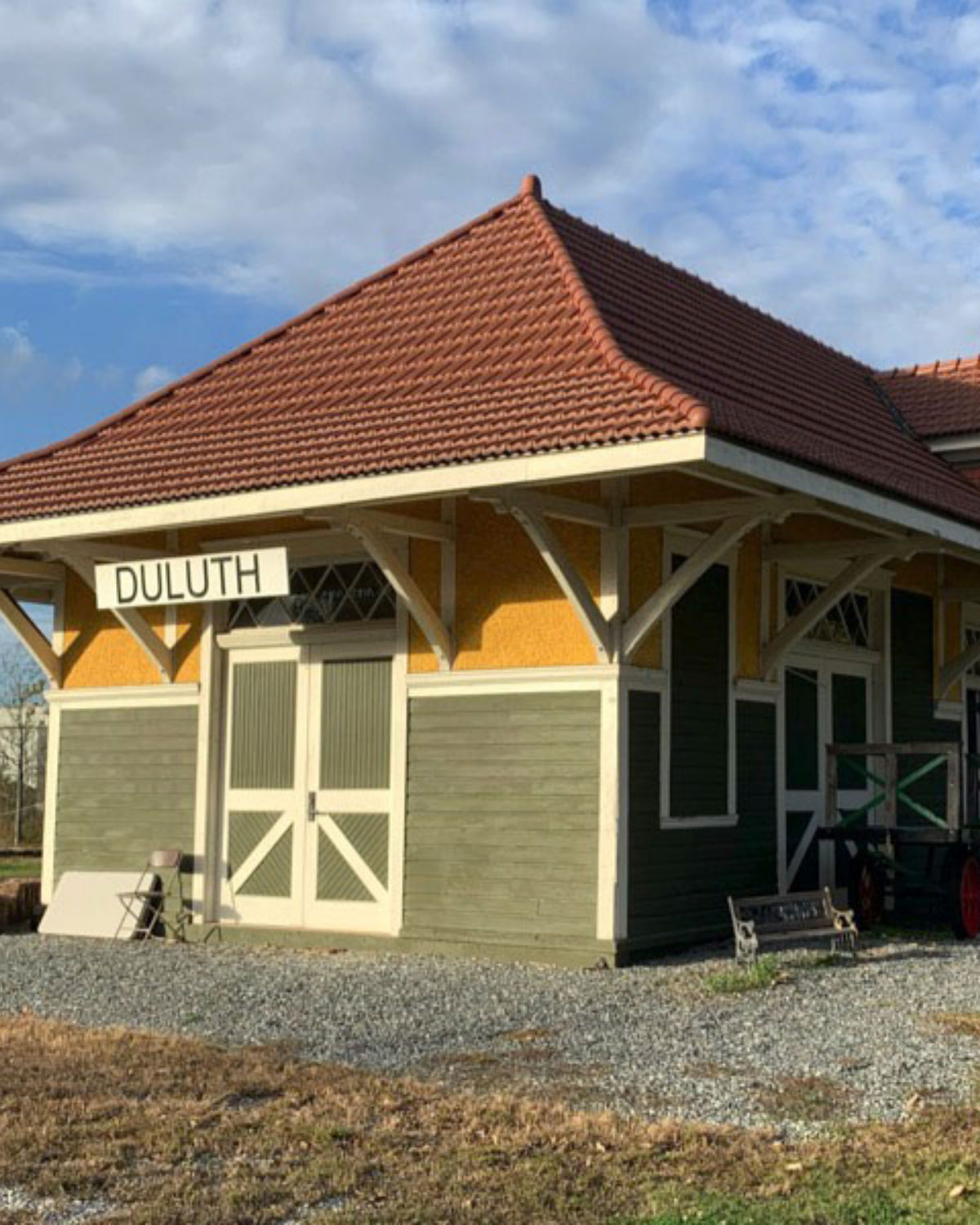The charming yellow-painted historic Duluth Train Depot with green trim and a covered platform in Duluth, Georgia