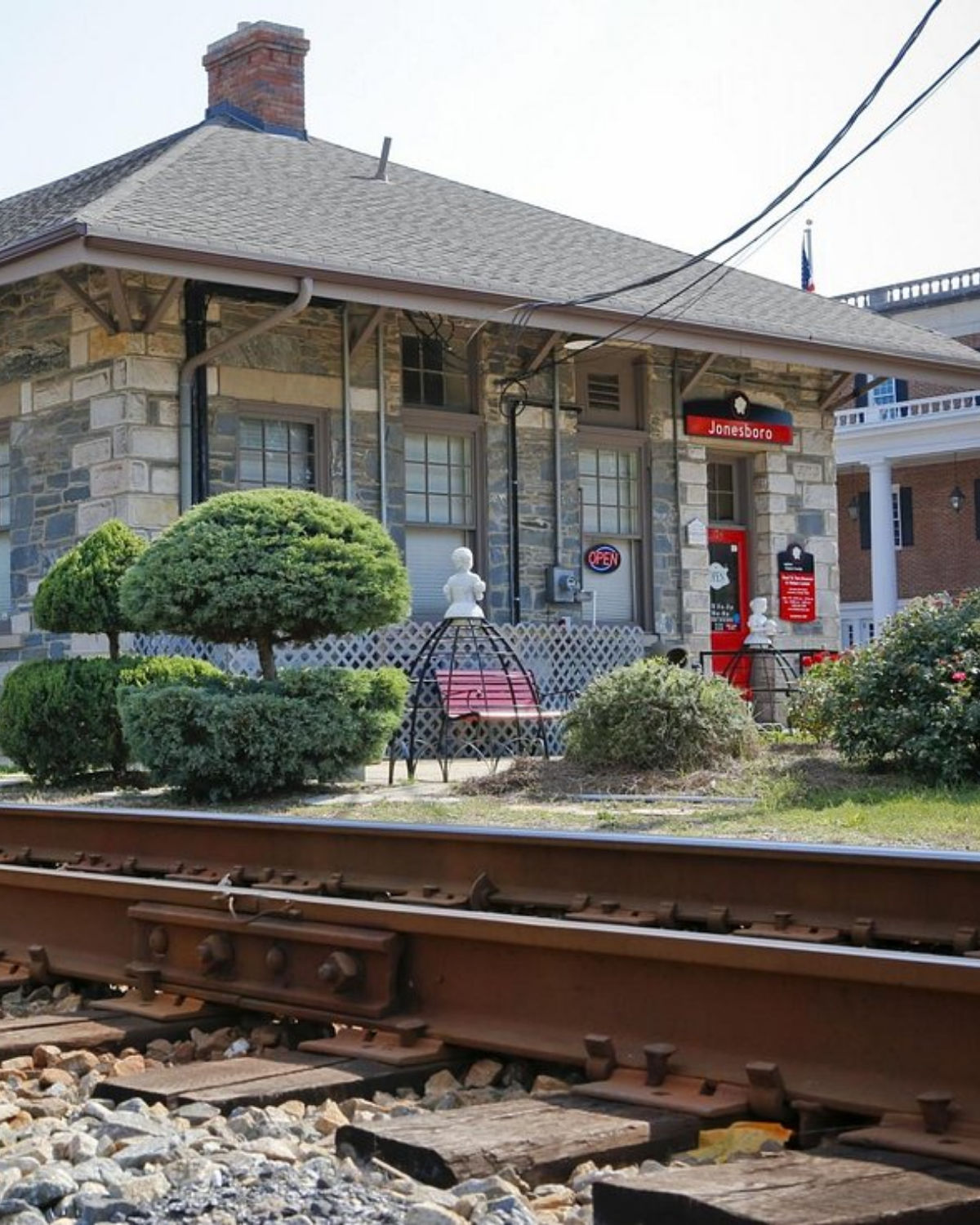 The exterior of the historic Jonesboro Train Depot with a red caboose on the tracks in Jonesboro, Georgia, home of the Road to Tara Museum