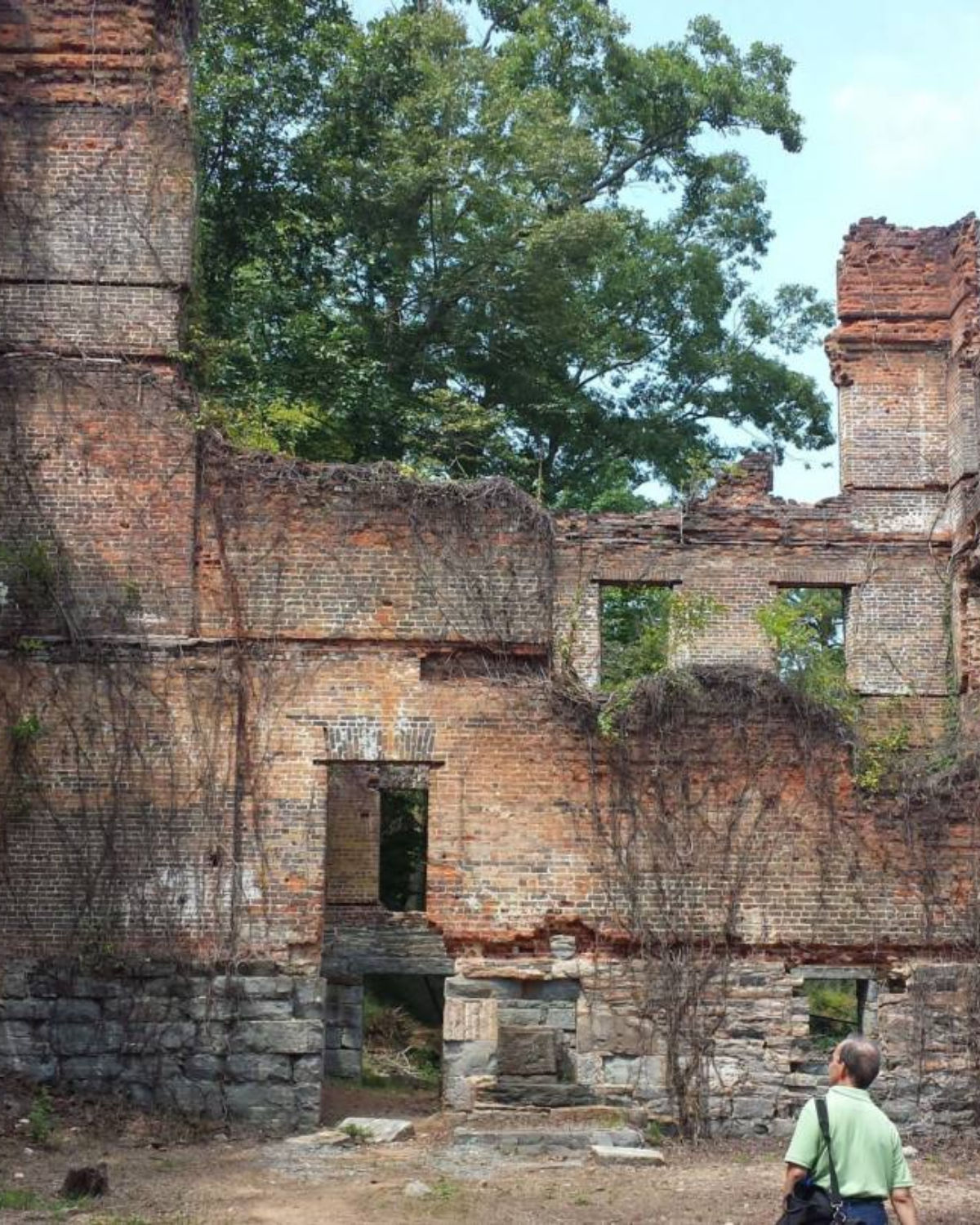 Weathered brick ruins of the historic New Manchester Mill covered in vines and surrounded by forest in Mableton, Georgia