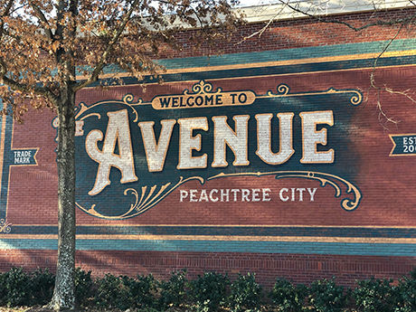 A mural on a brick wall depicting The Avenue in Peachtree City, GA