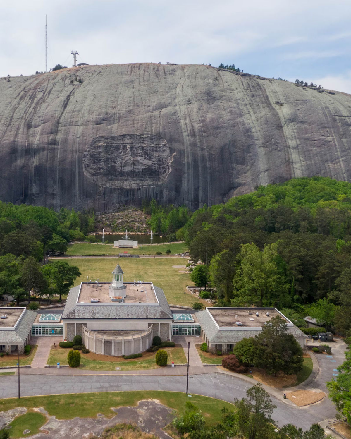 Aerial view of the Confederate Memorial Carving on the granite face of Stone Mountain with the surrounding park and Atlanta skyline in the distance