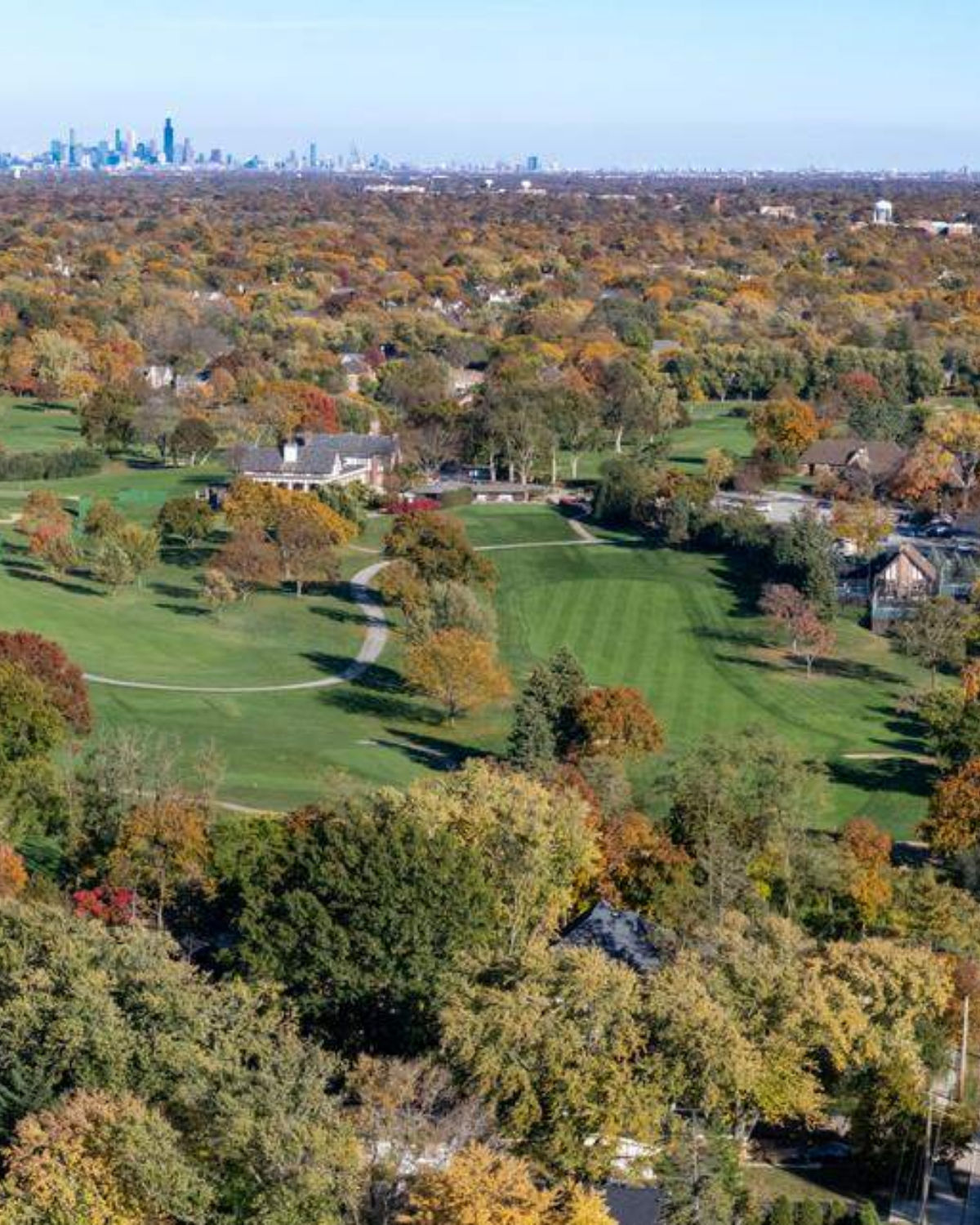 Aerial autumn view of a scenic golf course with vibrant fall foliage and tree-lined fairways in Clarendon Hills, Illinois
