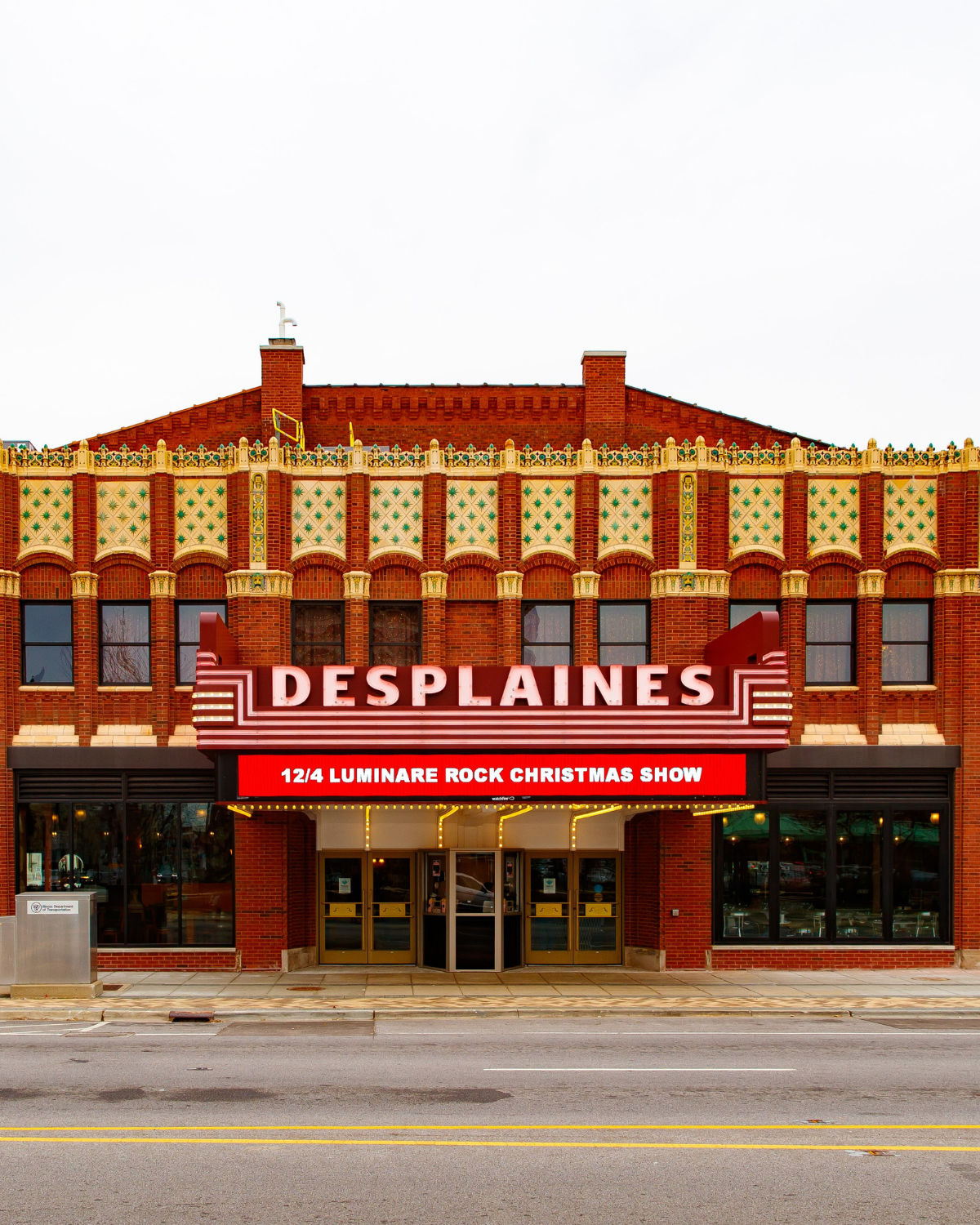 Street view of the historic Des Plaines Theatre and a lit up marquee in Des Plaines, IL