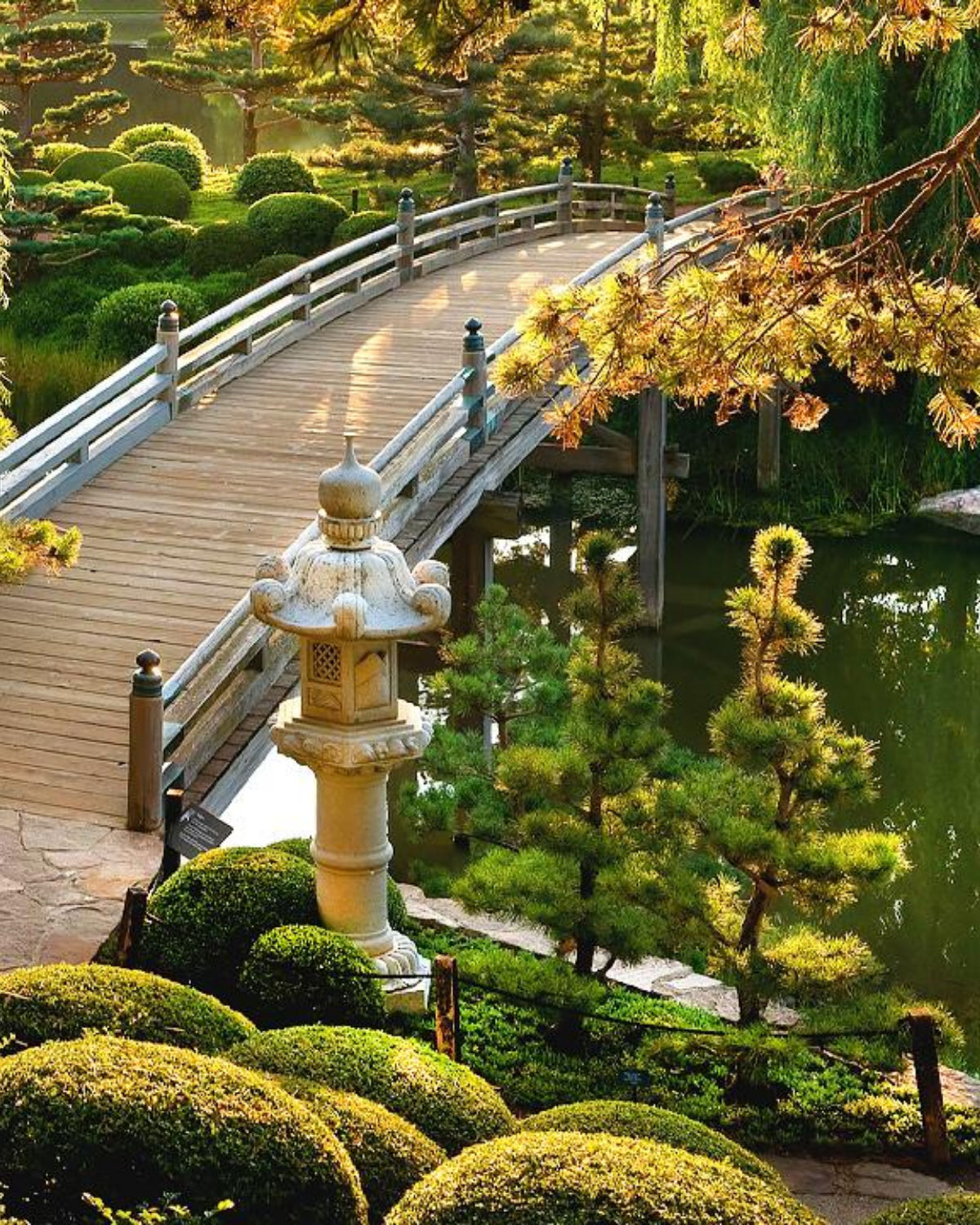 Serene Japanese garden with a stone lantern, ornamental bridge, and lush koi pond at the Chicago Botanic Garden near Highland Park, Illinois