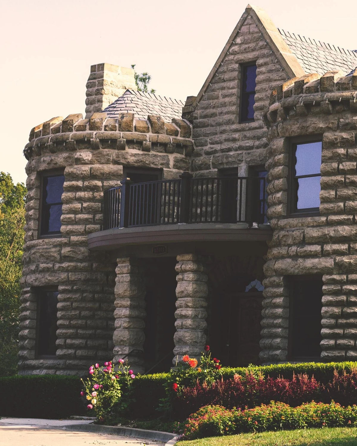 The historic rough-cut stone facade of Caenen Castle with turret details and arched windows in Shawnee, Kansas