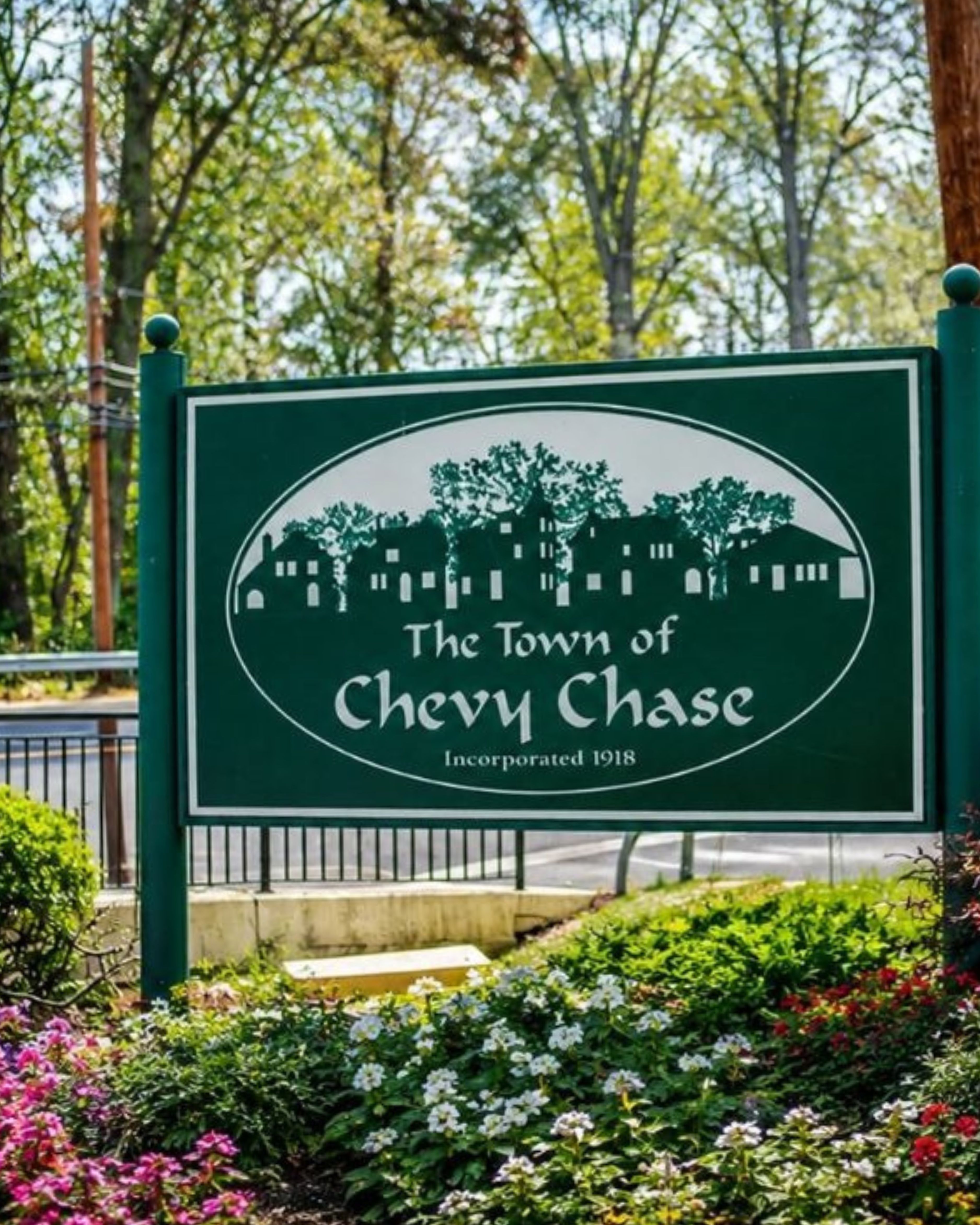 Welcome sign for the Town of Chevy Chase, MD, surrounded by colorful flowers and greenery, highlighting the community’s historic character and tree-lined setting.