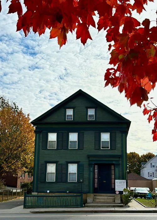 The historic Lizzie Borden House in Fall River, Massachusetts, framed by vibrant autumn foliage, highlighting the city’s rich history, iconic architecture, and classic New England character.