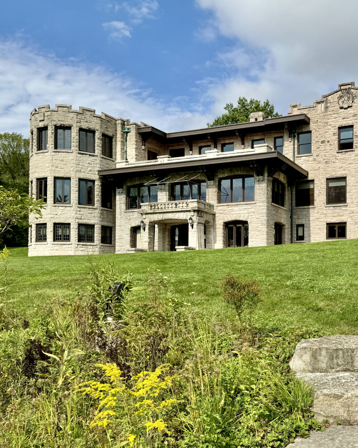 The grand limestone facade and manicured grounds of Fair Lane, the historic Henry Ford estate in Dearborn, Michigan