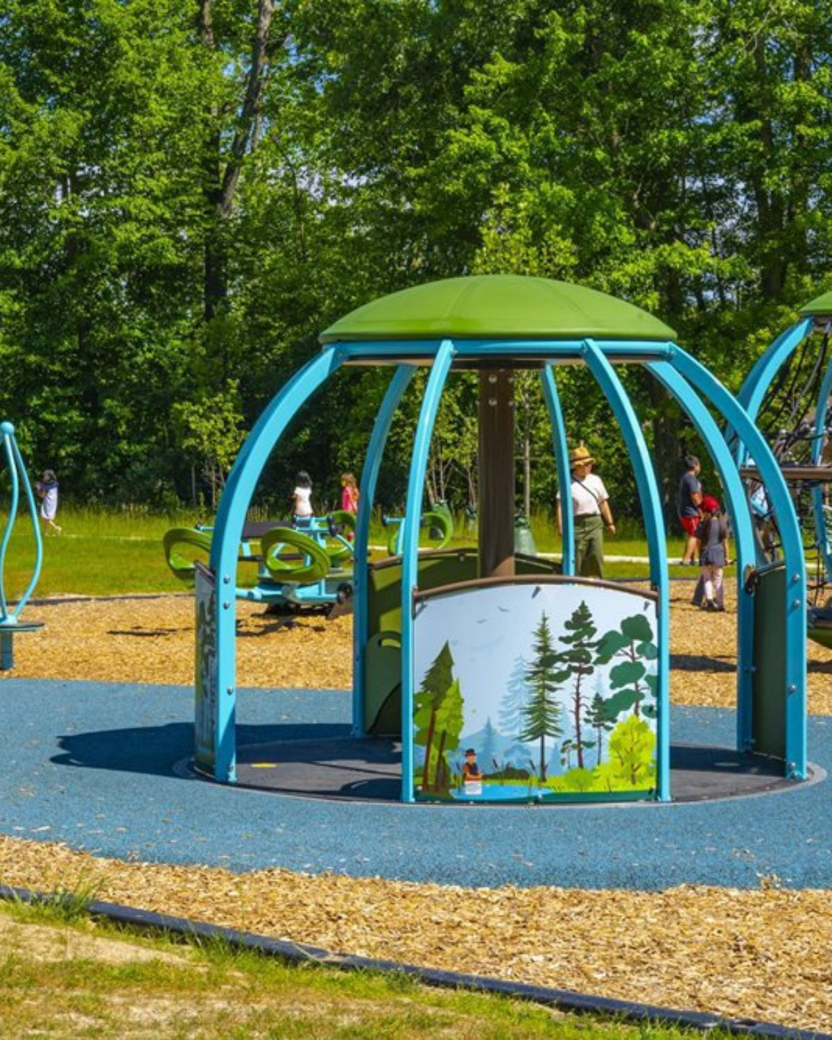 Modern colorful playground structure surrounded by lush green trees and open green space at a well-maintained park in Novi, MI
