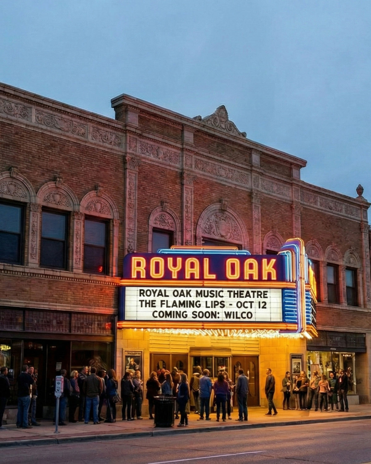 Evening street view of the Royal Oak Music Theatre in Royal Oak, Michigan, with its bright neon ŇROYAL OAKÓ sign glowing above the sidewalk