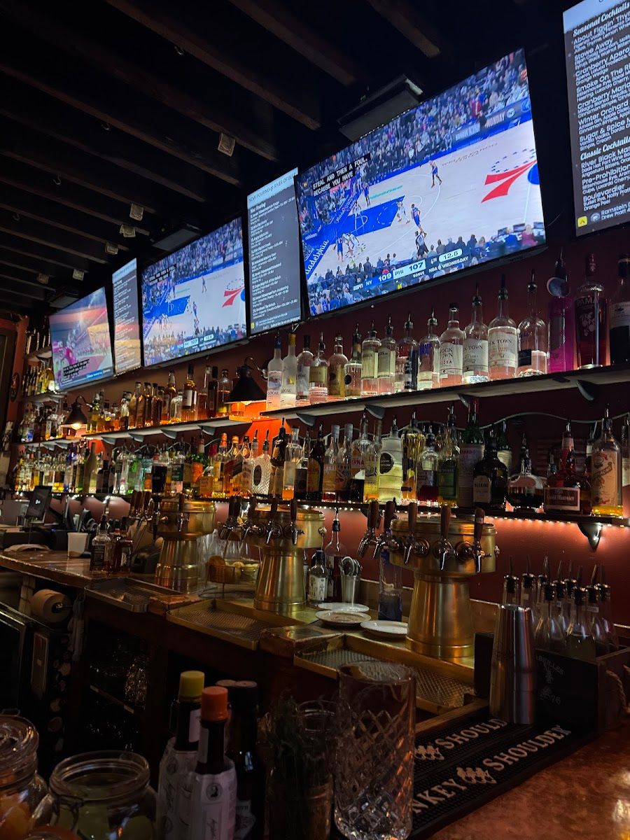 Interior of River Of Beer, a gastropub and craft beer bar at 133 Main Street in Bloomingdale, New Jersey, featuring a long bar, beer taps, televisions, and casual pub-style seating.