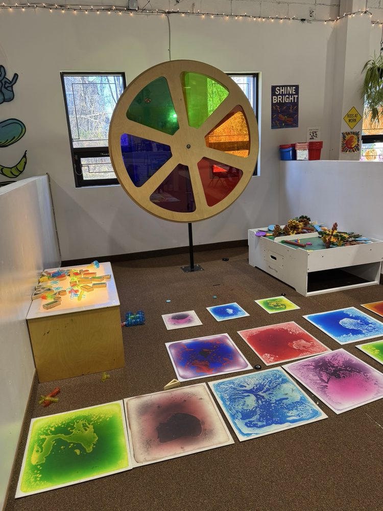 Children's interactive learning and play space near Florham Park, New Jersey, featuring a large multicolored sensory wheel, colorful floor panels, hands-on activities, and creative exhibits.