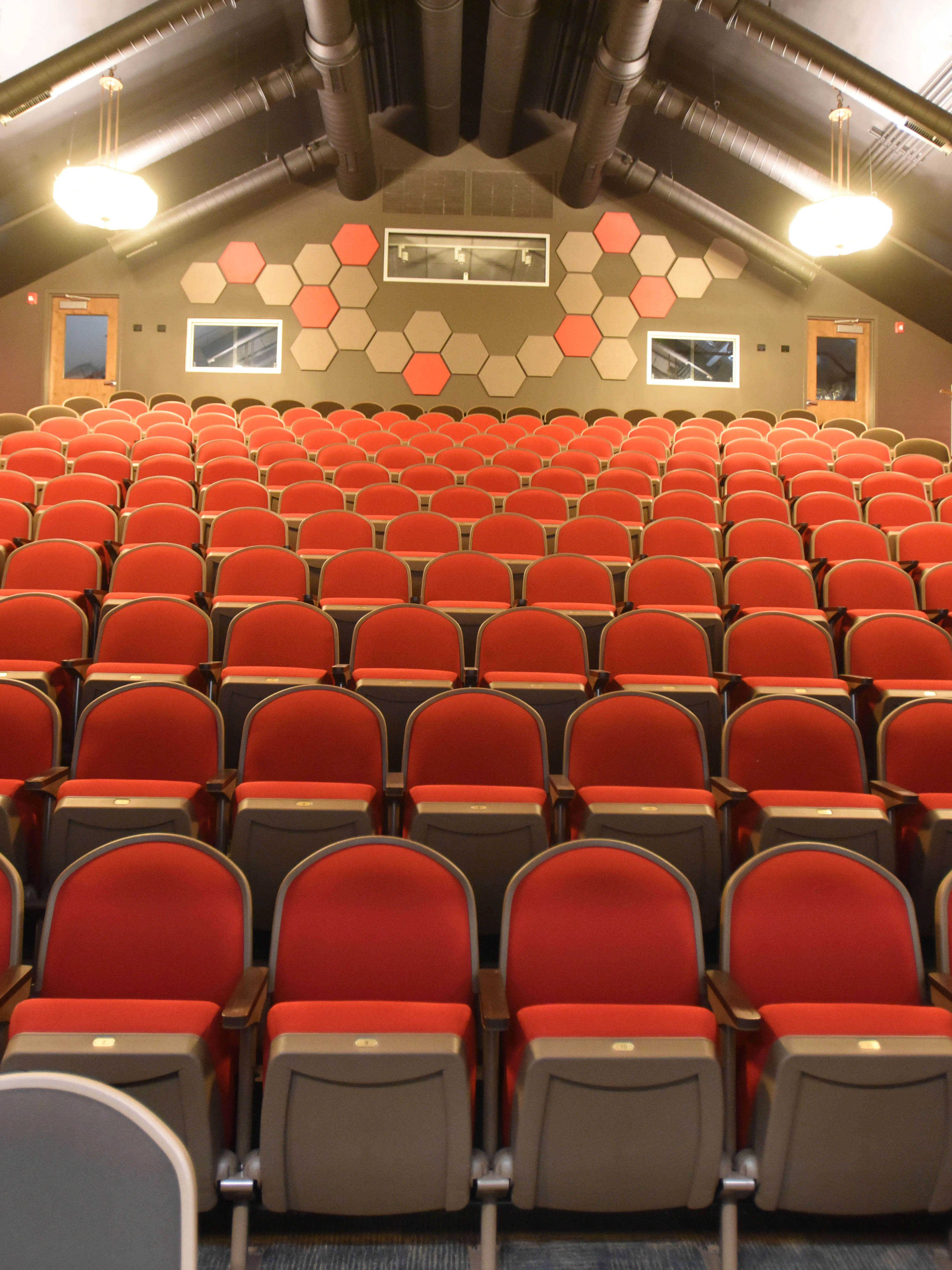 Interior of the Hackensack Performing Arts Center (HACPAC) in Hackensack, New Jersey, featuring rows of red auditorium seats near HappyNest laundry pickup and delivery customers.