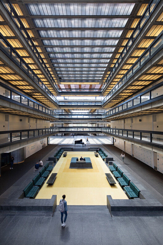 Interior of the Bell Works complex in Holmdel, New Jersey, featuring its expansive modern atrium, skylight ceiling, open walkways, seating areas, and public gathering space.