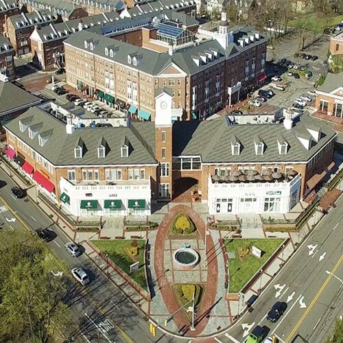Aerial view of Livingston, NJ town center featuring a central clock tower, surrounding shops, and a walkable plaza with nearby residential and commercial buildings