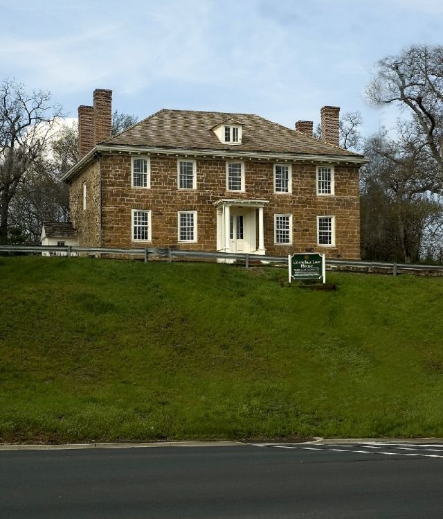 The Cornelius Low House Museum, a historic colonial landmark in Piscataway, New Jersey, surrounded by open green space.