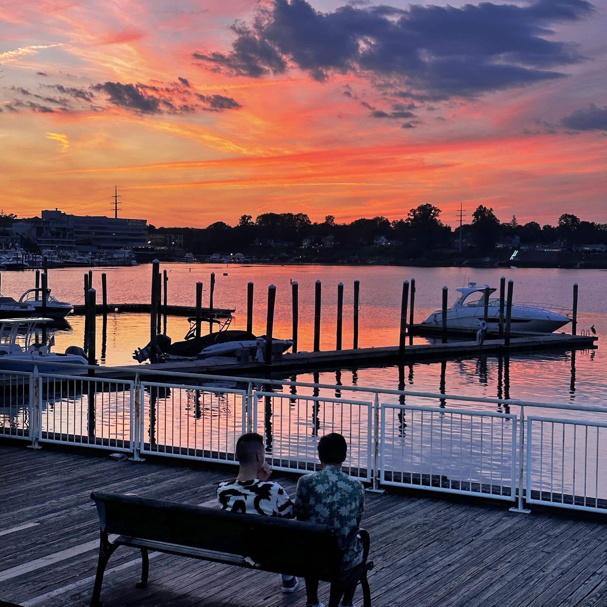 Sunset over the Navesink River in Red Bank, New Jersey, with boats docked along the waterfront and visitors enjoying the scenic riverfront atmosphere that makes this Monmouth County destination so vibrant and inviting.