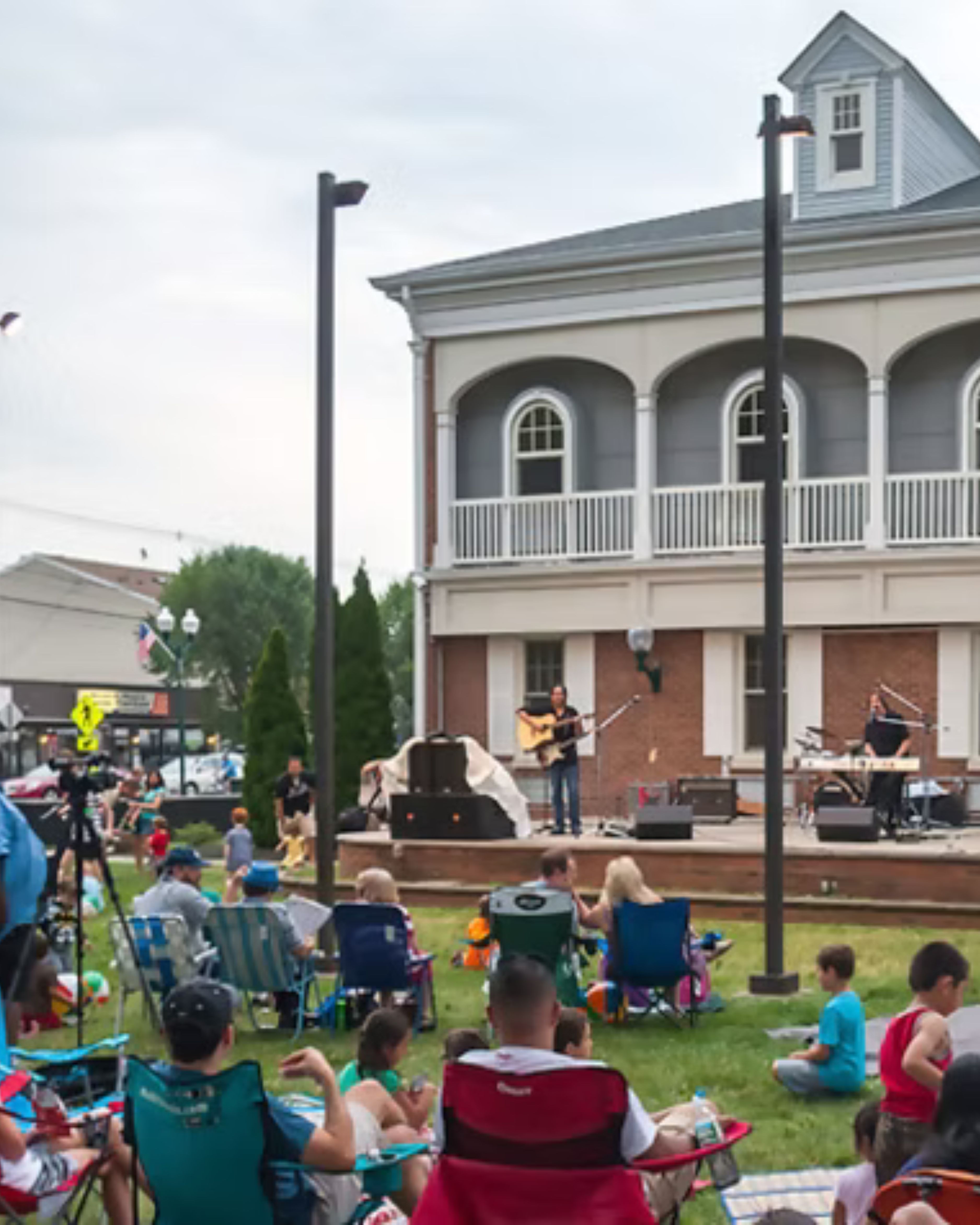 Community concert event in Scotch Plains, New Jersey, featuring families gathered on the lawn enjoying live music in a welcoming neighborhood setting