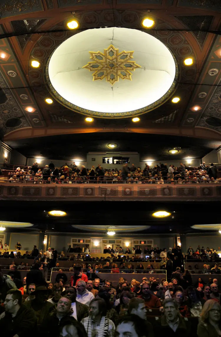 Interior of the historic Lafayette Theatre near Totowa, New Jersey, featuring its ornate ceiling, decorative architecture, balcony seating, and a large audience gathered inside the theater.