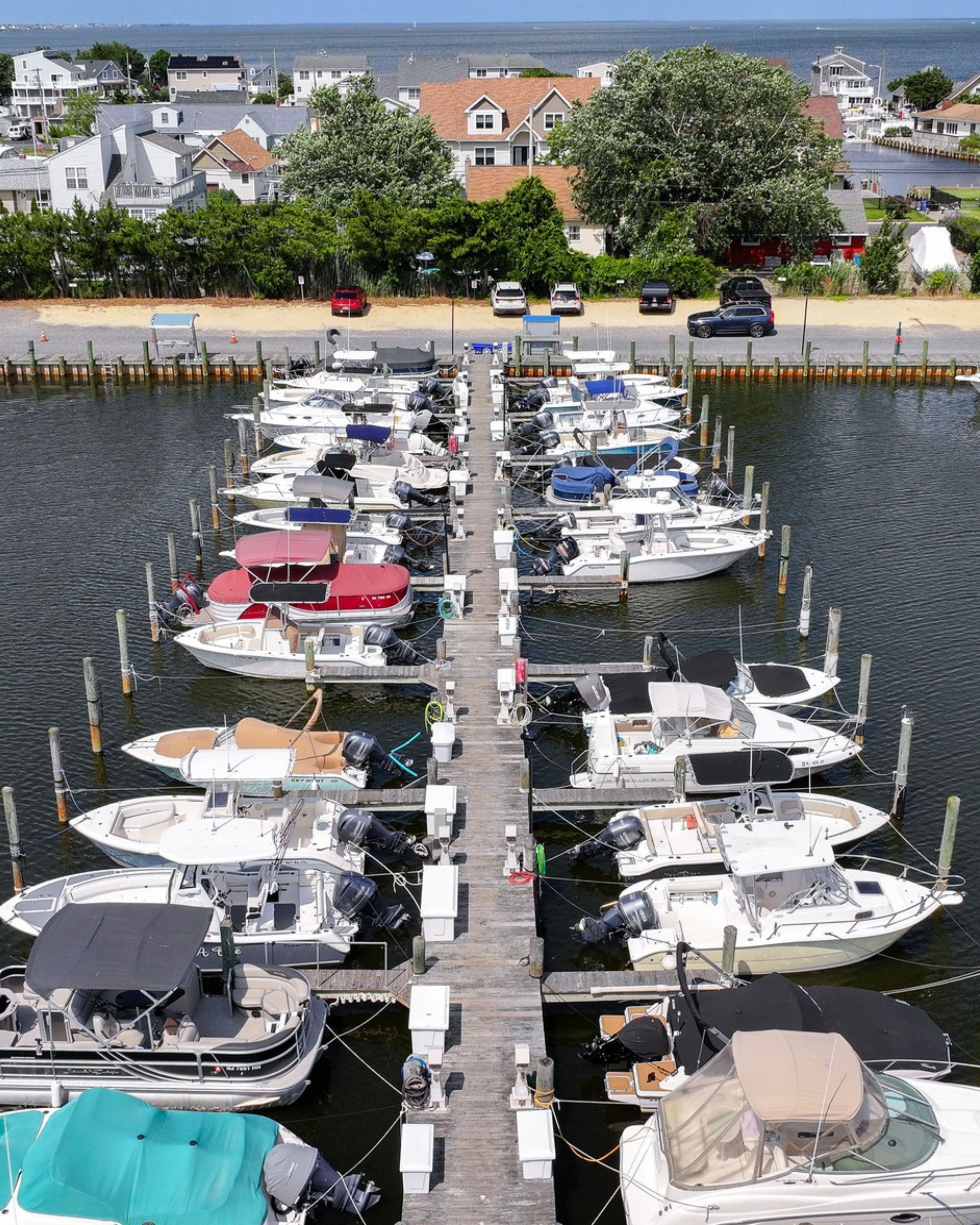 Aerial view of a marina in Waretown, NJ, featuring rows of docked boats, waterfront homes, and scenic coastal waterways along the Jersey Shore.