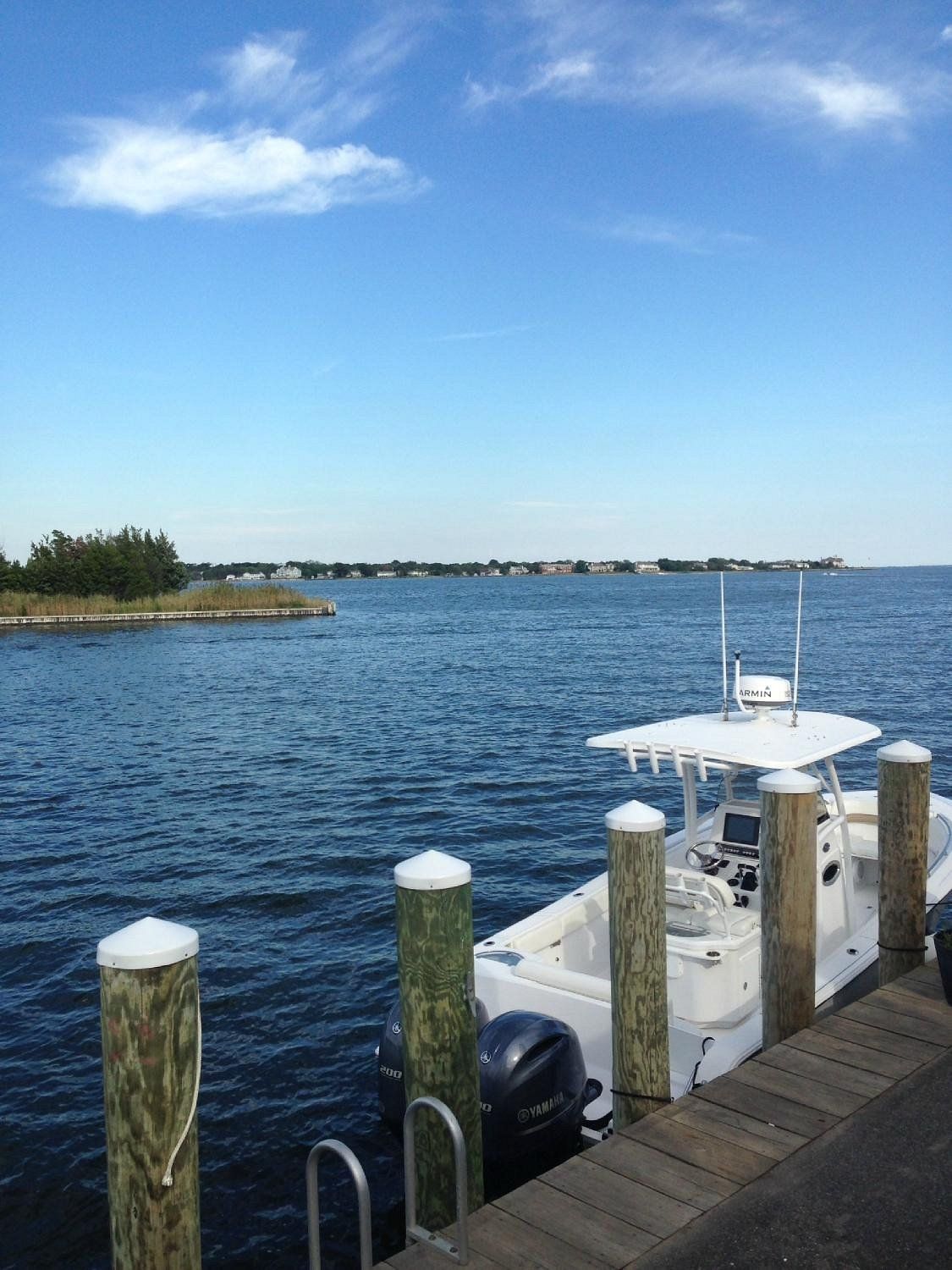 Boat docked along the waterfront in Bay Shore, New York, overlooking calm coastal waters and scenic Long Island shoreline views under a clear blue sky.