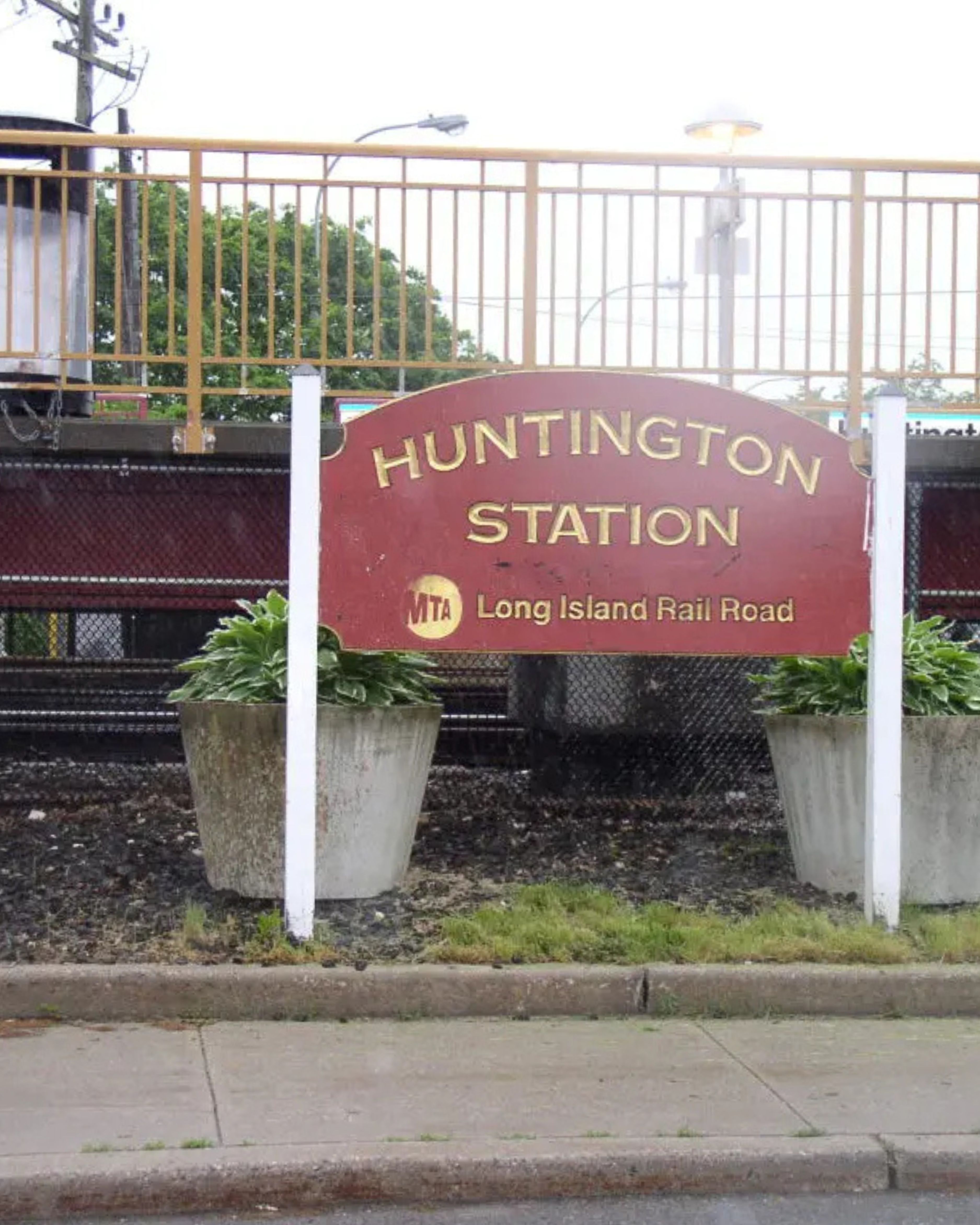 Huntington Station Long Island Rail Road sign in New York, featuring the busy commuter rail platform and suburban Long Island surroundings.