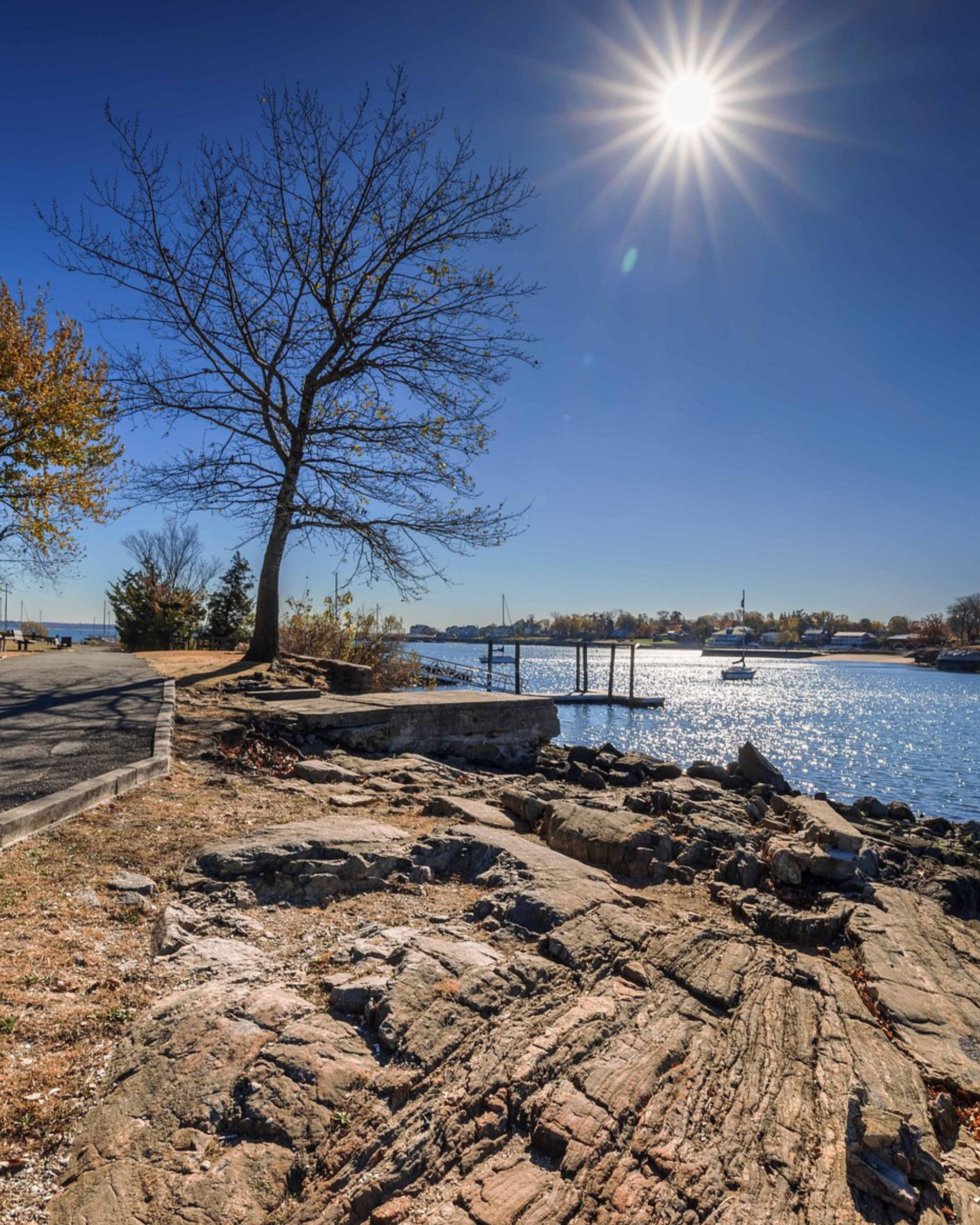 Scenic waterfront at Five Islands Park in New Rochelle, New York, featuring rocky shoreline, marina docks, and sparkling views across Long Island Sound.