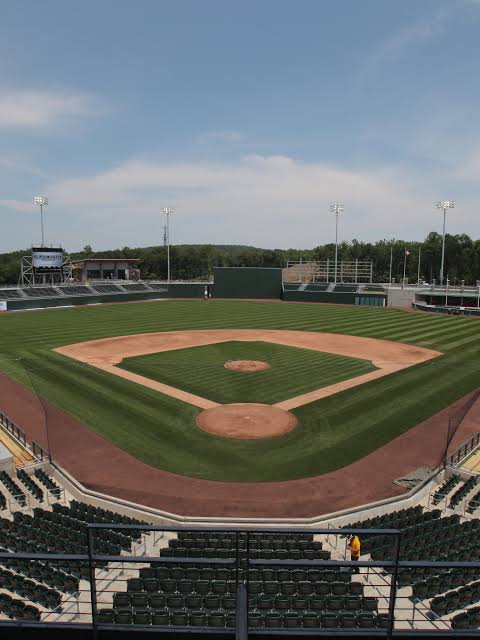 Baseball field at Clover Stadium in Pomona, New York, with green outfield grass, stadium seating, and surrounding Rockland County hills.