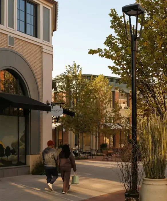 The Shops at Atlas Park near Queens Village, New York, featuring a pedestrian-friendly outdoor shopping district with storefronts, landscaped walkways, and visitors enjoying the open-air setting.