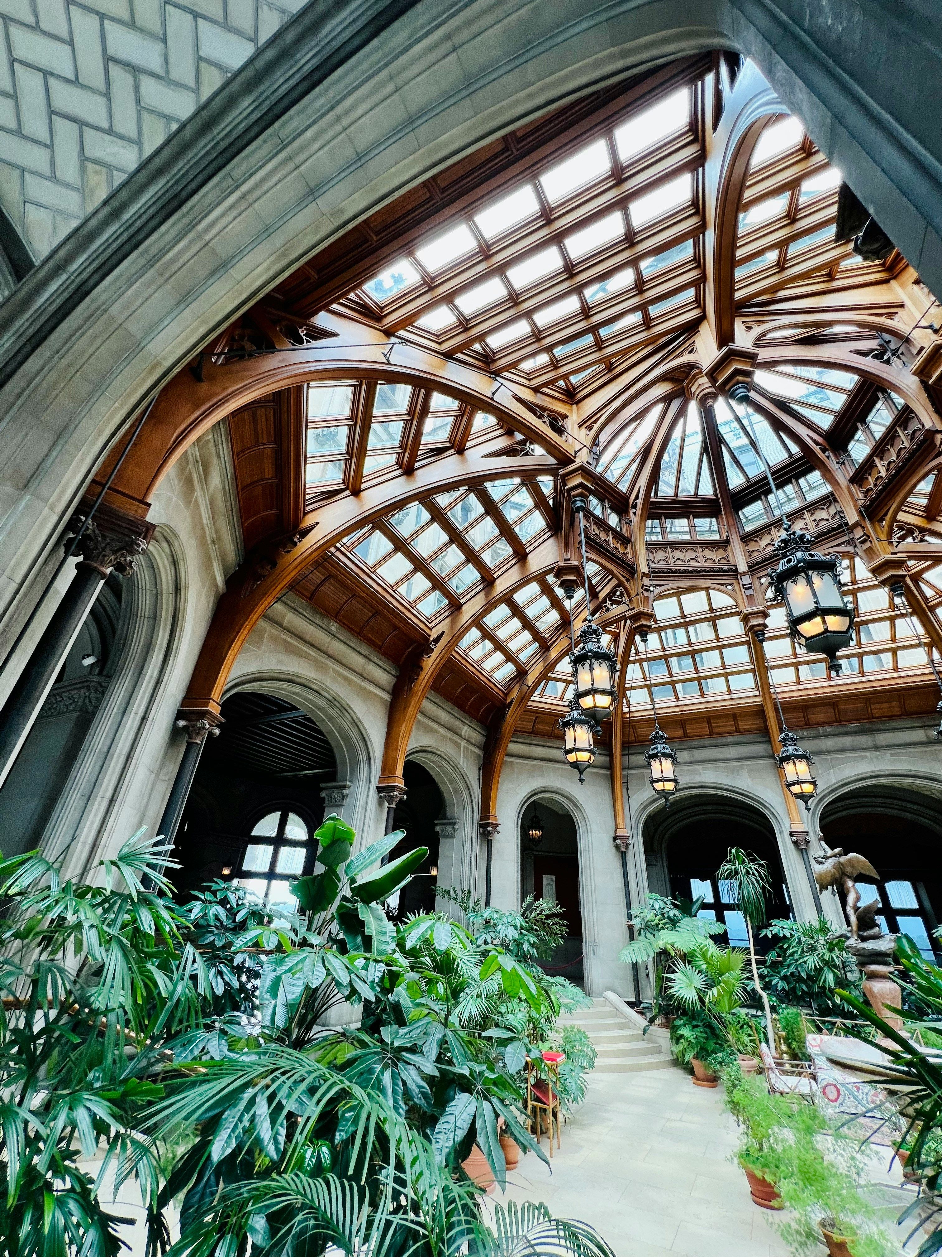 The stunning ornate glass dome ceiling of the Biltmore Estate conservatory with intricate iron framework in Asheville, North Carolina