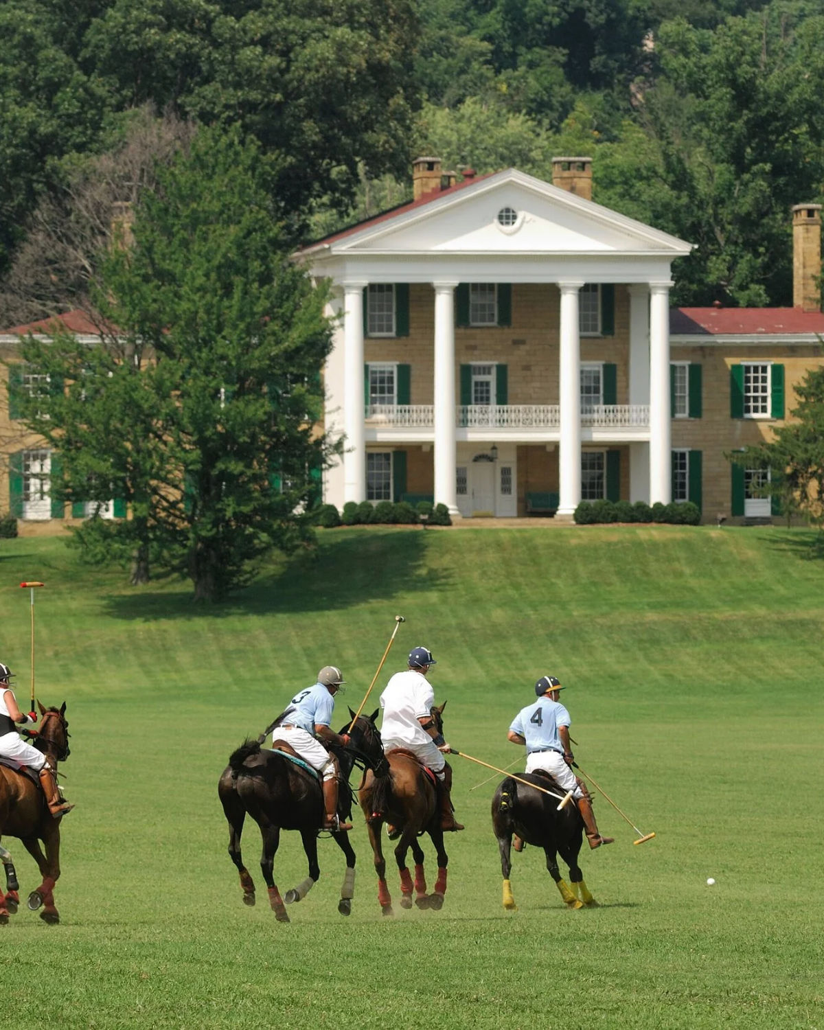 Elegant white-columned historic mansion with horseback riders on manicured green grounds in Granville, Ohio