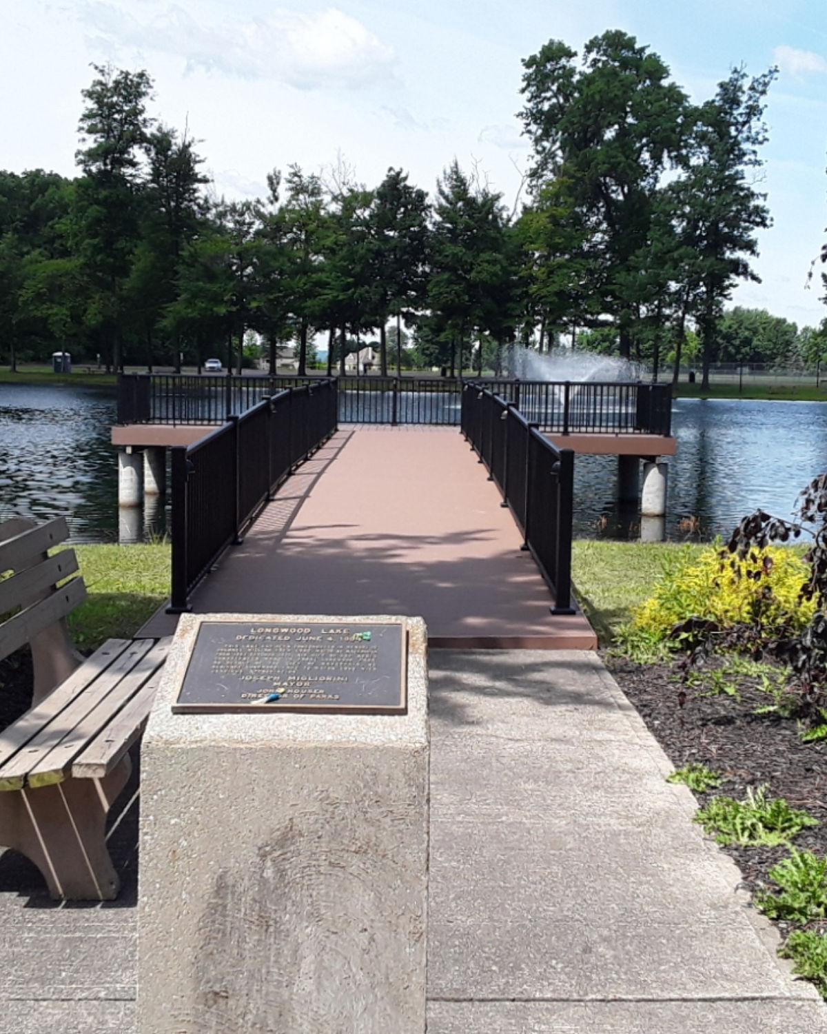 Peaceful wooden pier extending over a calm lake in a serene park setting in Macedonia, Ohio