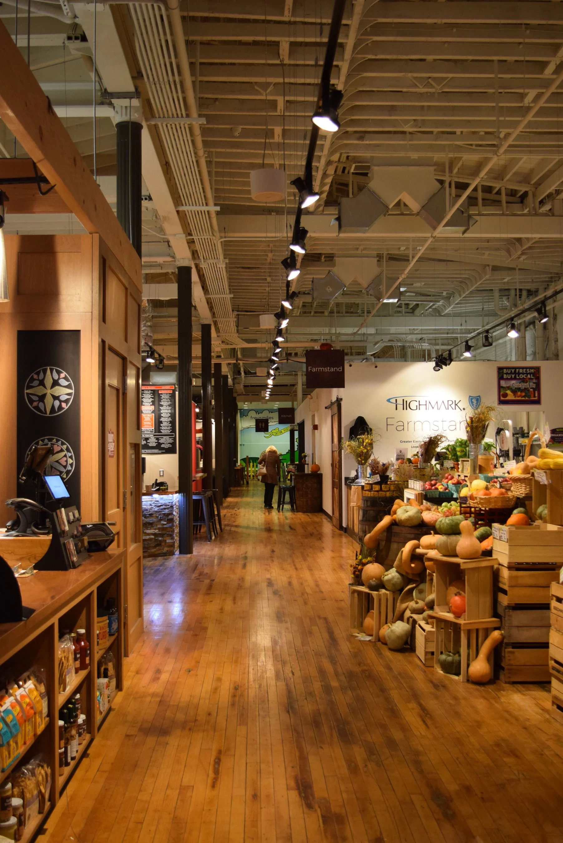 Interior of the Easton Public Market in Easton, Pennsylvania, featuring local produce vendors, artisan goods, and a spacious indoor marketplace with exposed wood flooring.