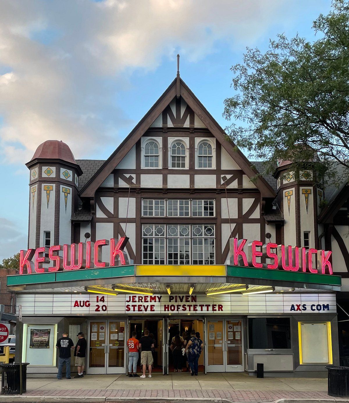 Exterior view of the Keswick Theatre near Fort Washington, Pennsylvania, featuring its historic marquee entrance, Tudor-style architecture, and visitors arriving for an evening event.