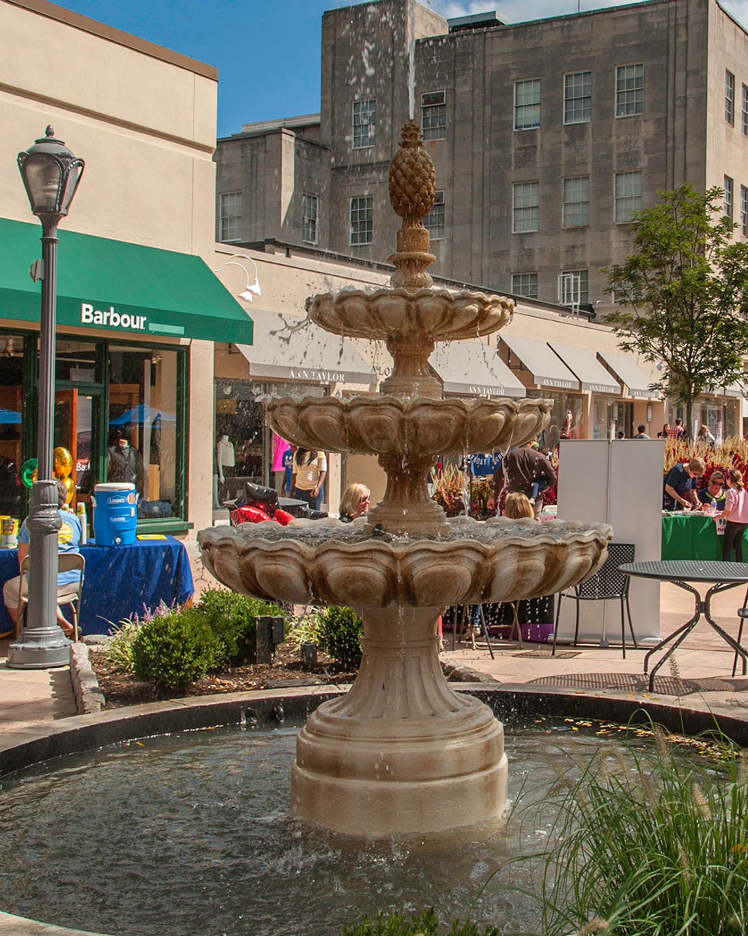 Decorative fountain in Suburban Square in Ardmore, Pennsylvania near Villanova University, surrounded by shops, outdoor seating, and people enjoying the Main Line shopping district.