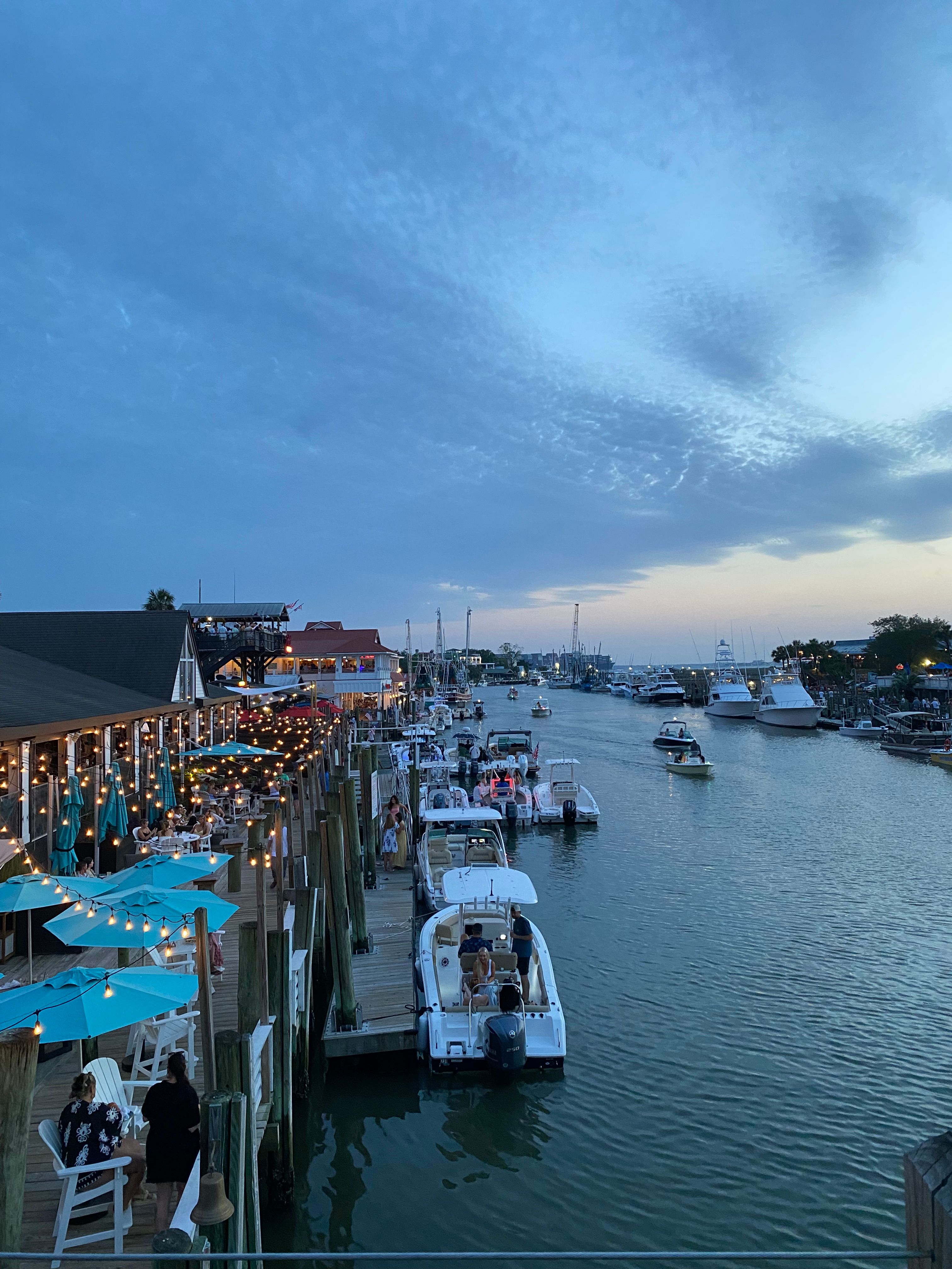 Colorful shrimp boats docked along Shem Creek at sunset in Mount Pleasant, South Carolina.