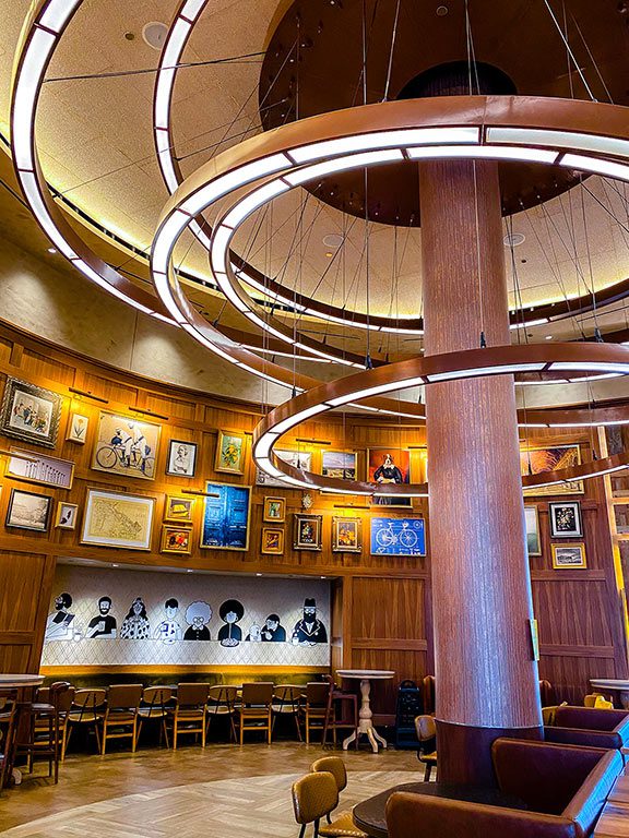 Modern restaurant interior in Falls Church, Virginia, featuring warm wood accents, contemporary circular lighting, local artwork, and upscale dining atmosphere.