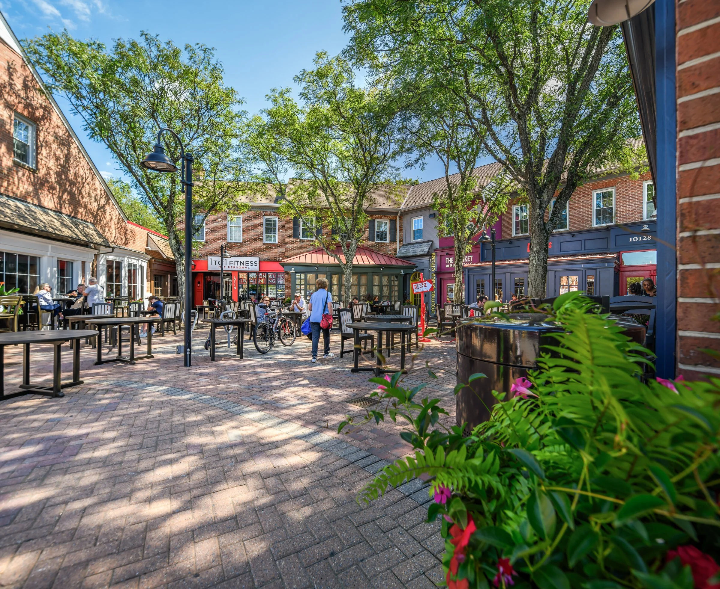 Outdoor shopping and dining area at Stonebridge at Potomac Town Center in Woodbridge, Virginia, featuring brick walkways, patio seating, local restaurants, and a lively, walkable community atmosphere—highlighting Northern Virginia lifestyle, retail destinations, and one of Prince William County’s most popular hubs for dining, shopping, and social activity.