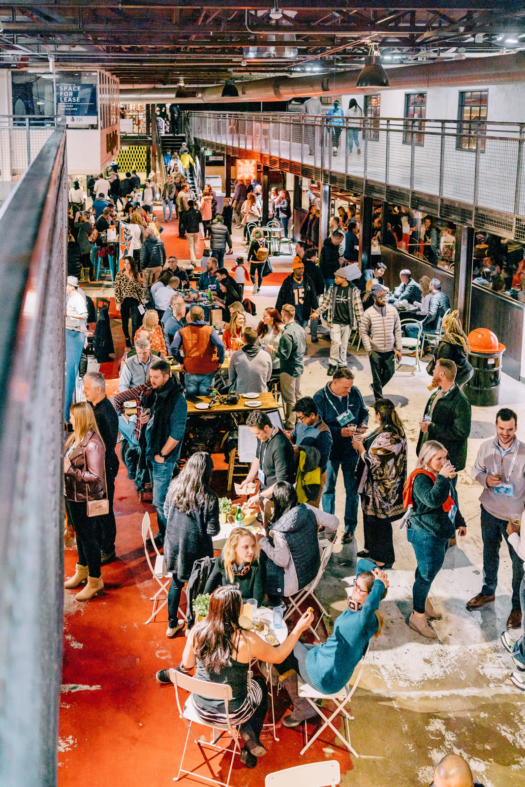 Busy indoor food hall in Aurora, Colorado featuring a lively crowd, local vendors, communal seating, and a vibrant social atmosphere inside a modern industrial-style market space.
