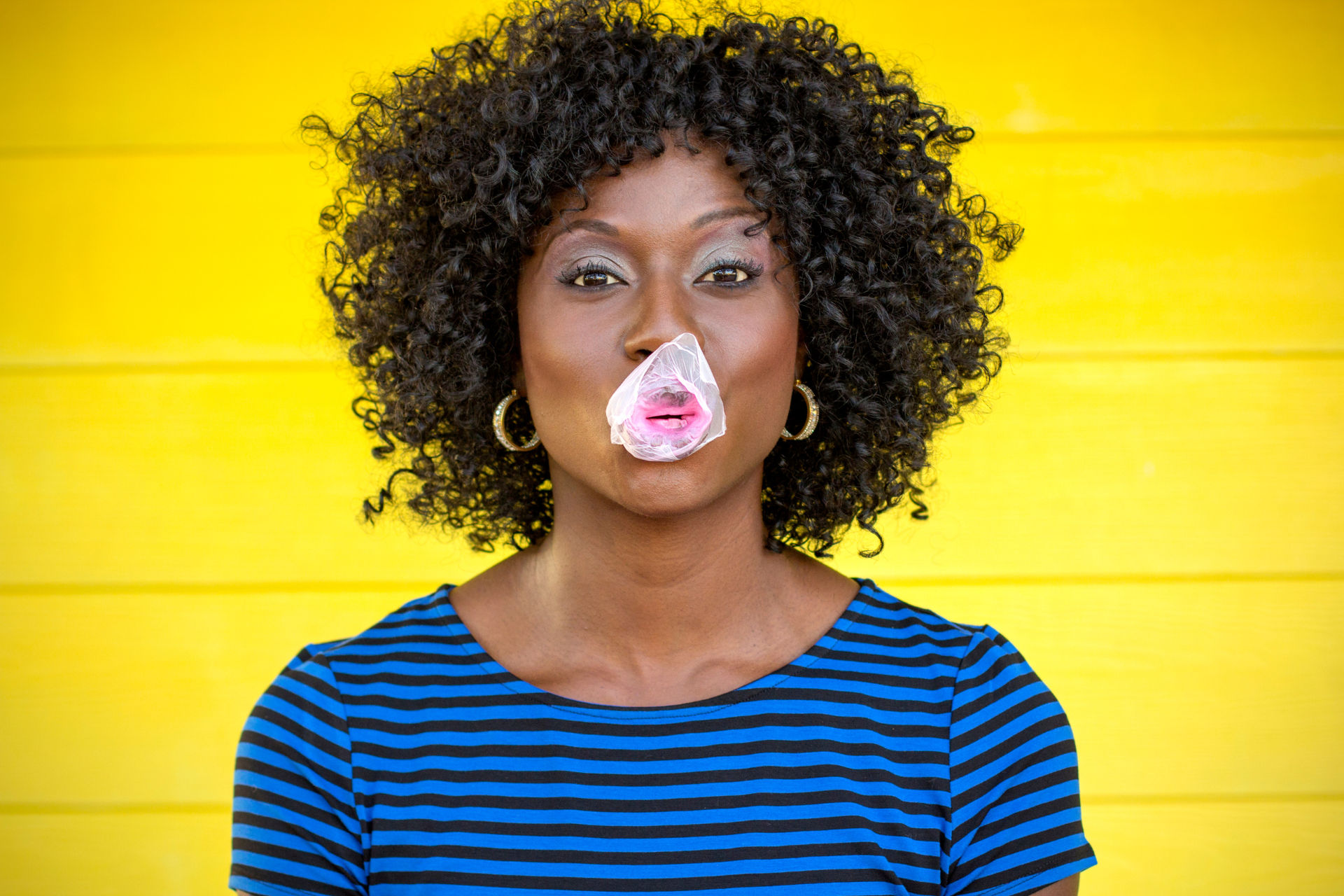 woman chewing bubble gum and blowing a bubble