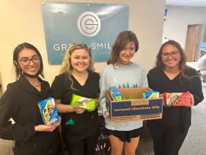 Great Smiles team members holding girl scout cookies