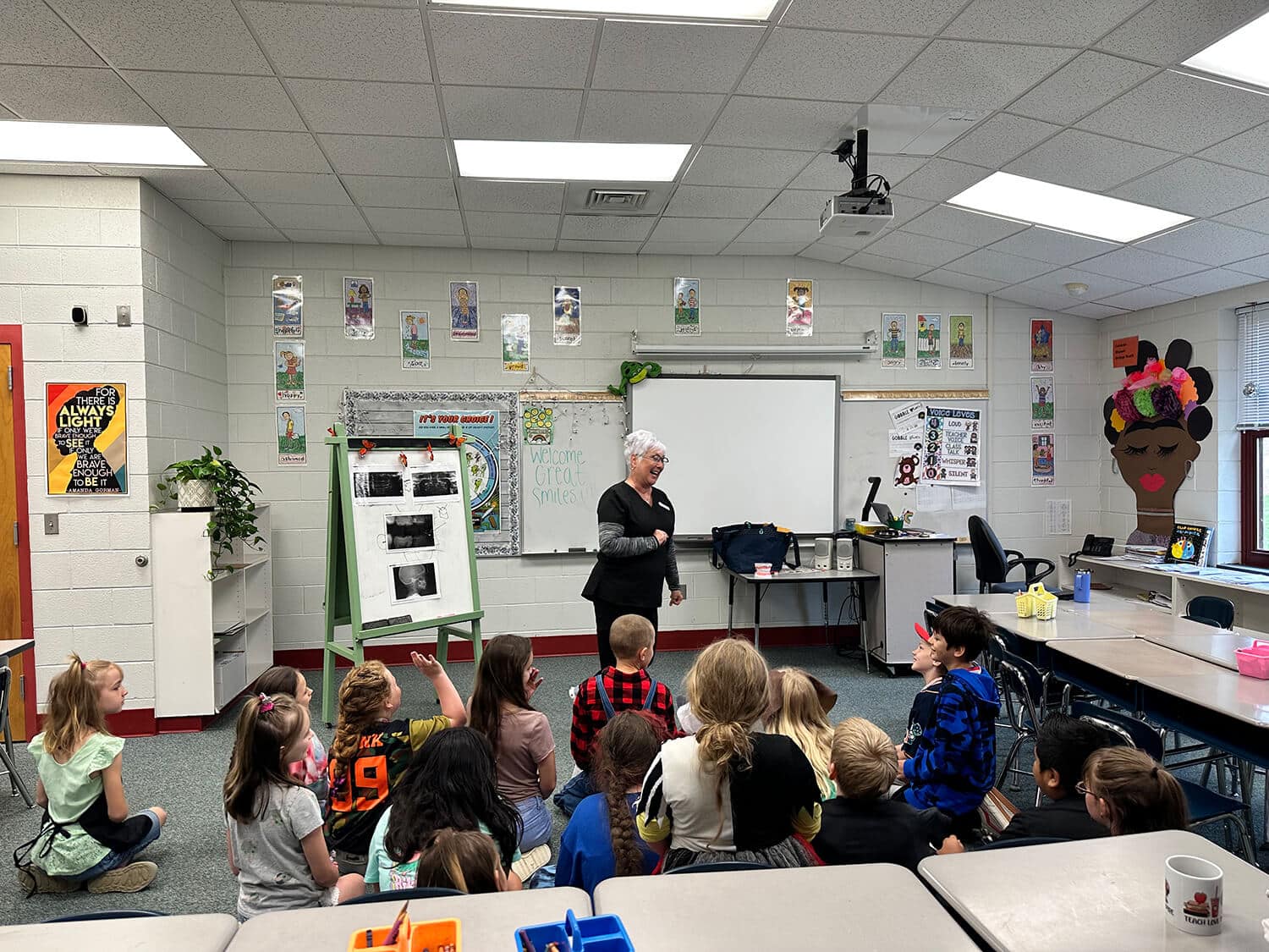 hygienist teaching a classroom of elementary students about dental health