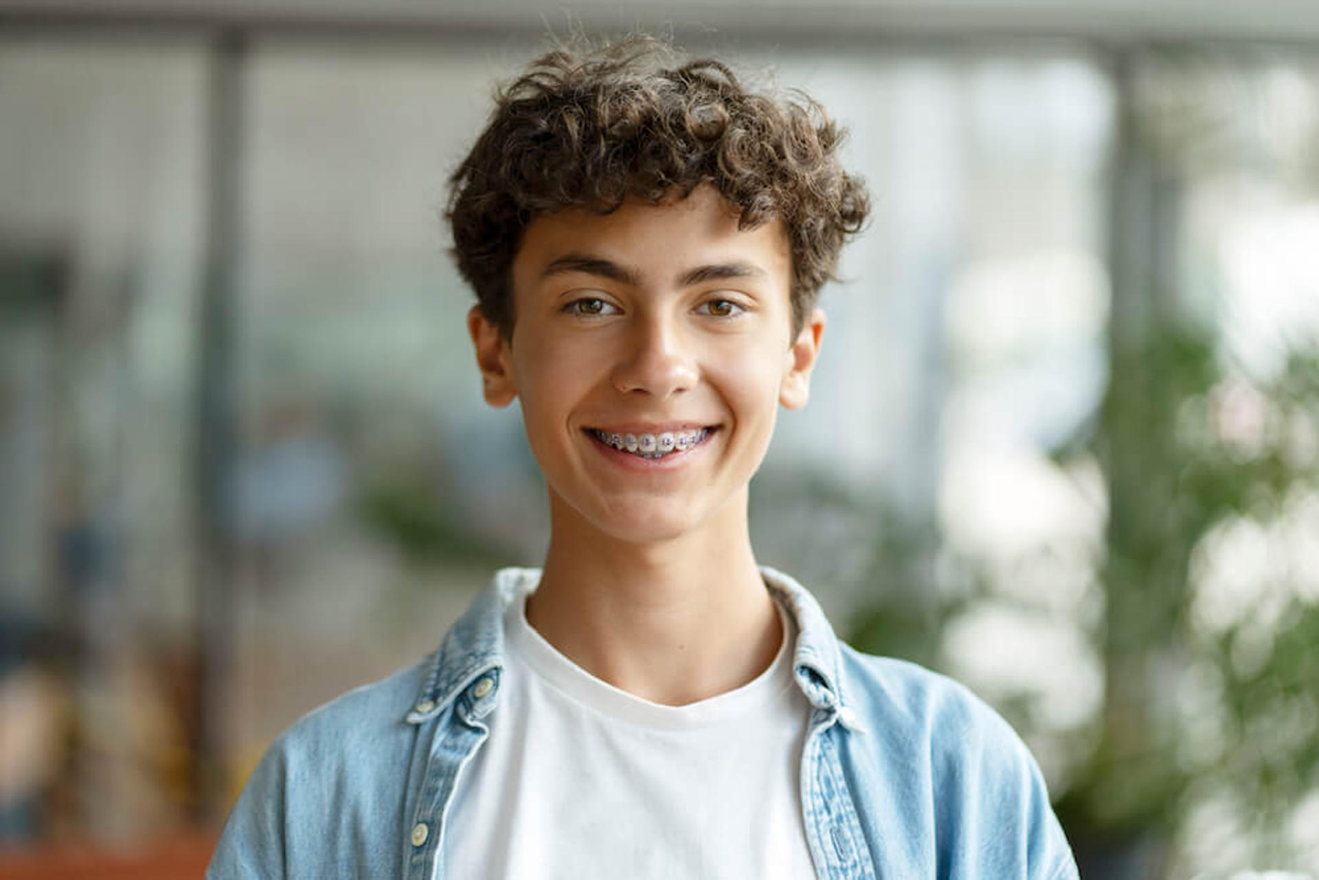 Smiling teen boy with Damon braces at Reynolds Orthodontics