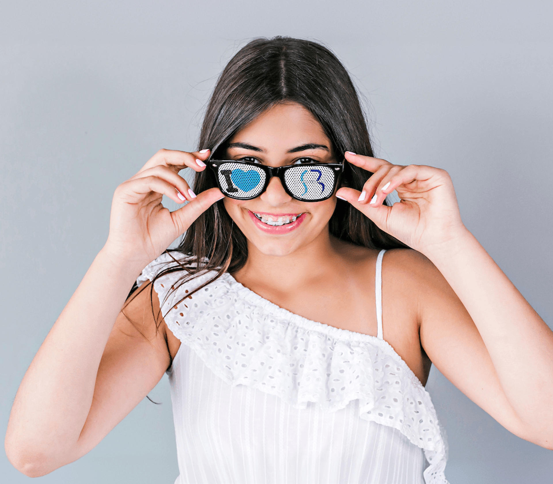 smiling girl with reynolds orthodontics branded glasses