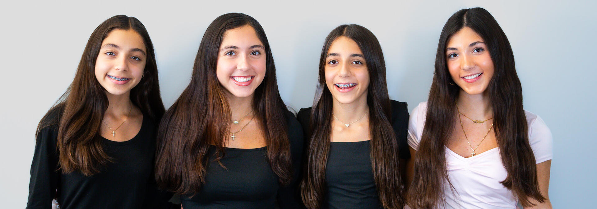 Two smiling girls completing new patient forms at Reynolds Orthodontics